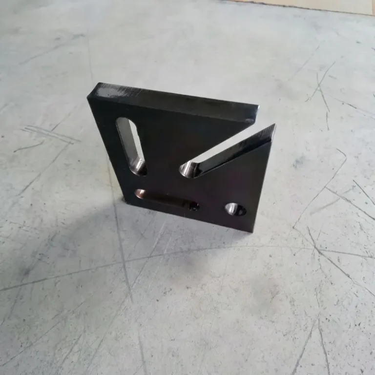 Thick steel plate part with cut slots and holes on a concrete floor